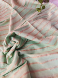 Close-up of a mint green khadi cotton saree with brown stripes on a light background
