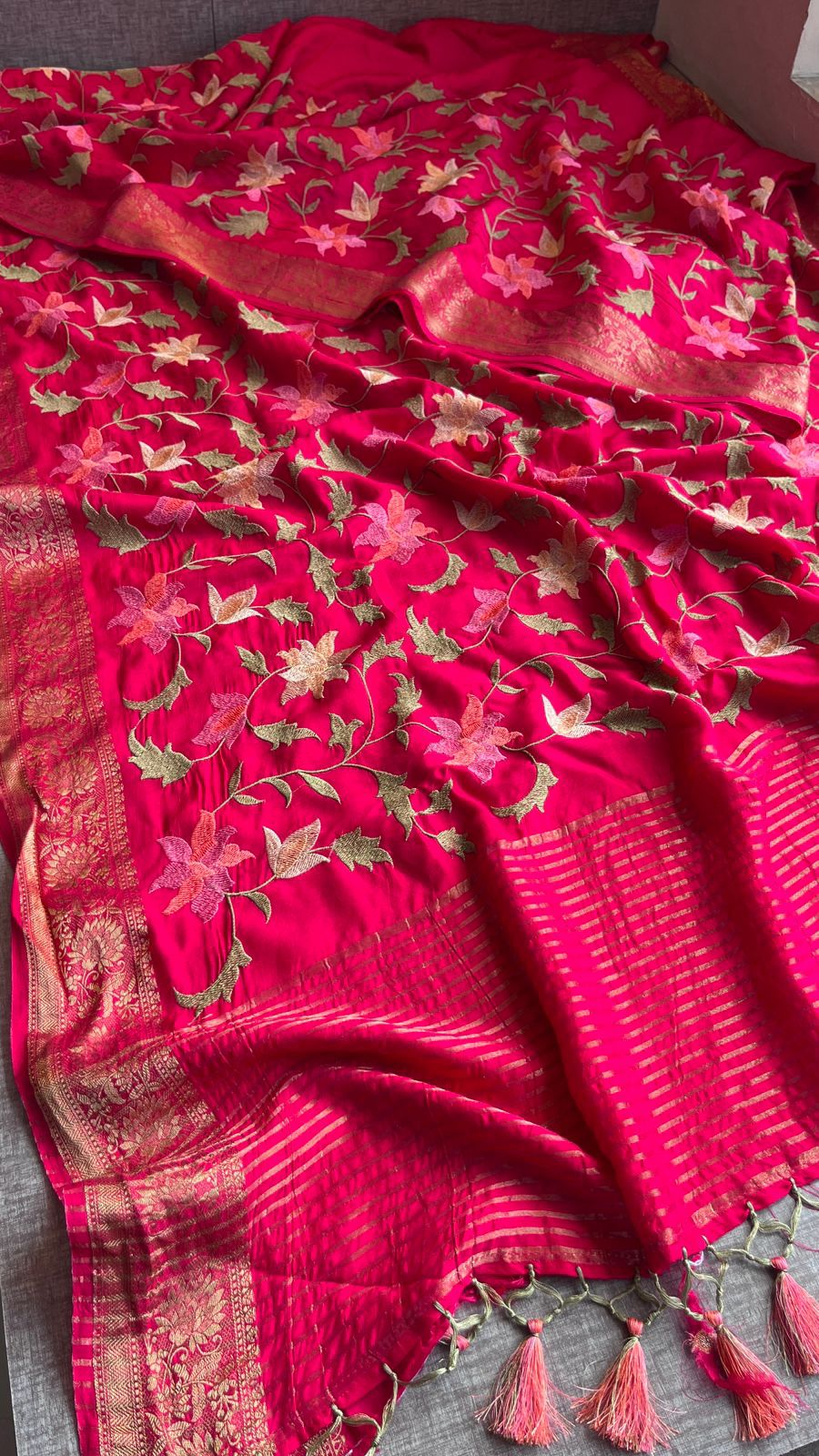 Red embroidered fabric with floral patterns on a plain background